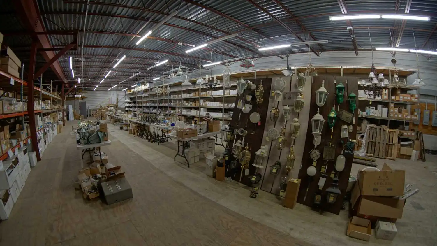 Inside the Hill Electric Supply warehouse, with lighting fixtures on display and stocked shelving